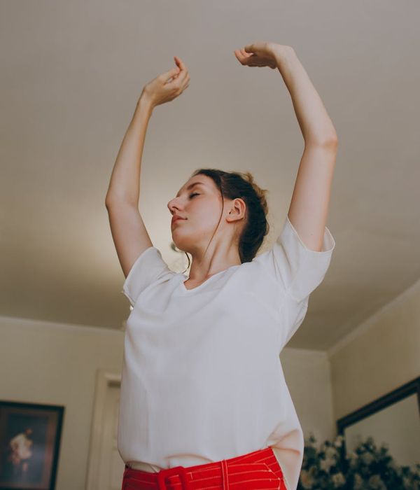 Person stretching in a bright, minimalist environment.